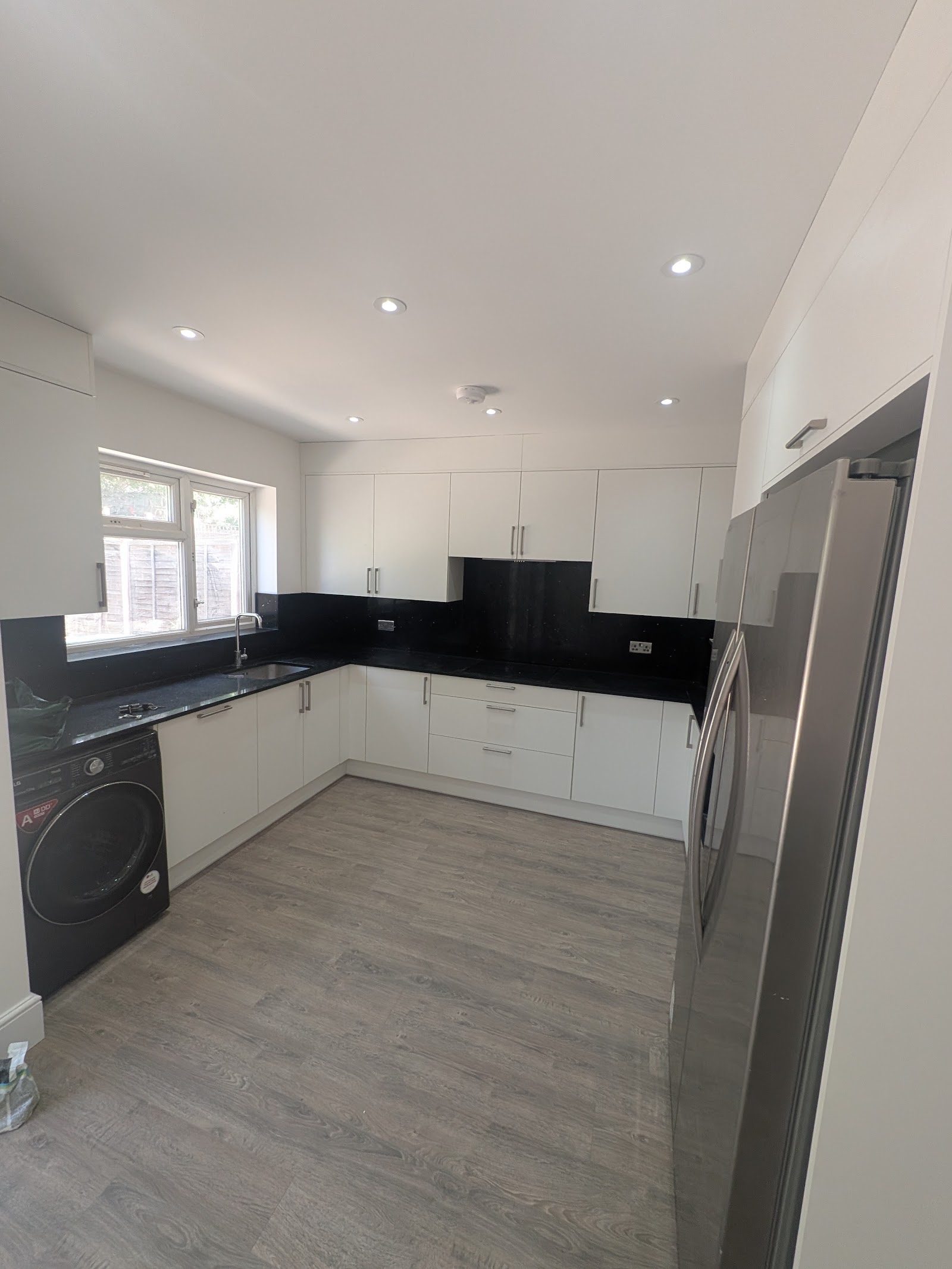 Finished Edgware HA8 kitchen with black stone worktop, splashback and integrated appliances