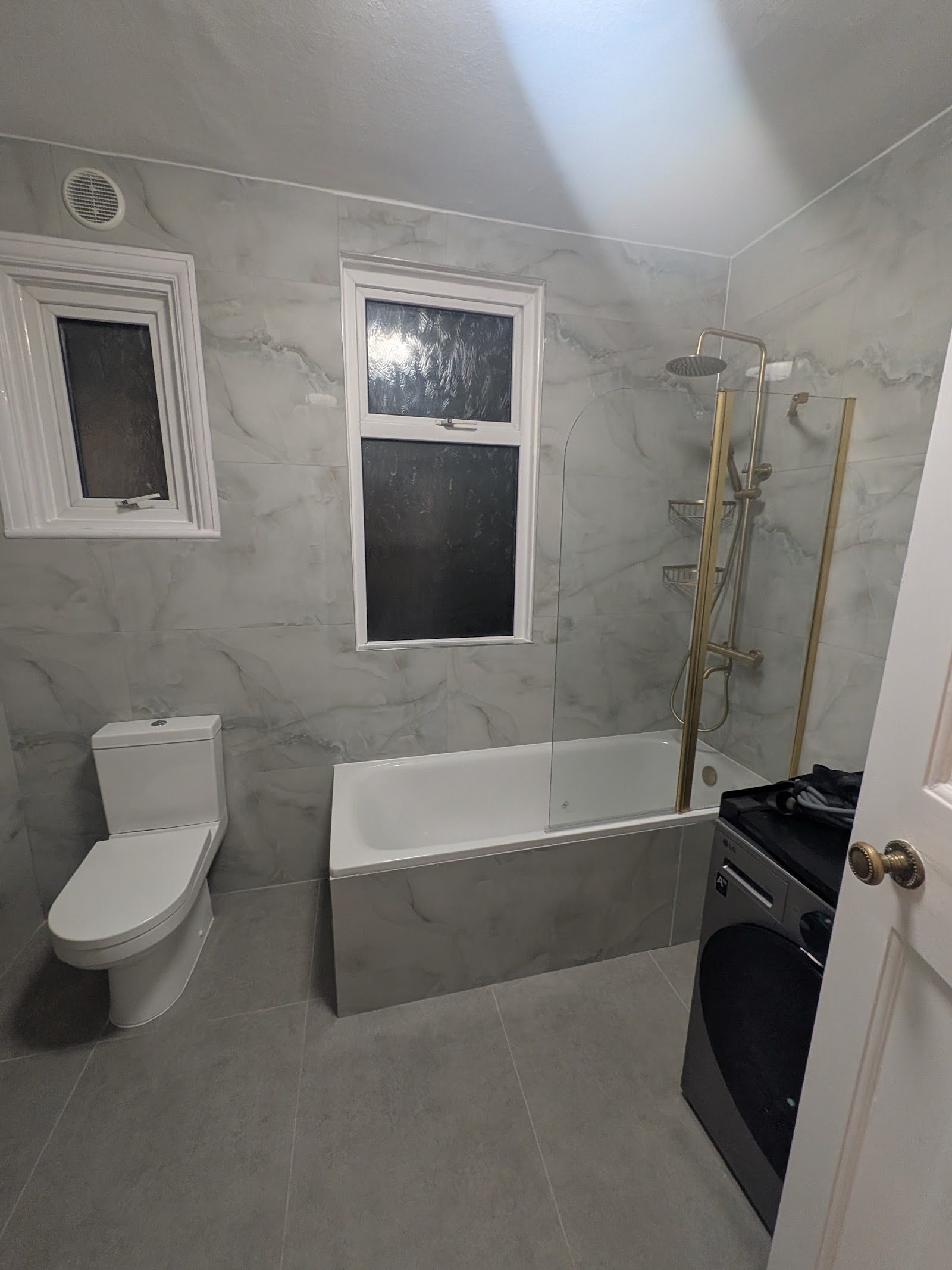 Bath with glass screen and brass shower fittings, Golders Green NW11