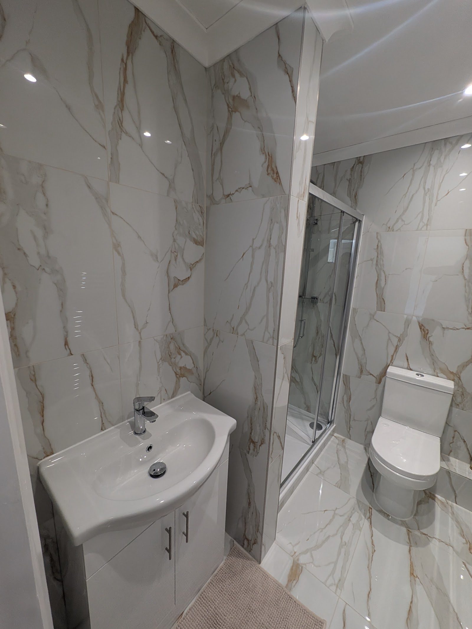 Marble-tiled bathroom with floating vanity and corner shower, Pinner HA5