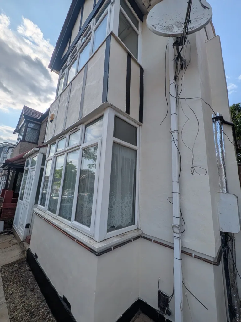 The same house repainted in fresh cream render with crisp black trim, Edgware HA8