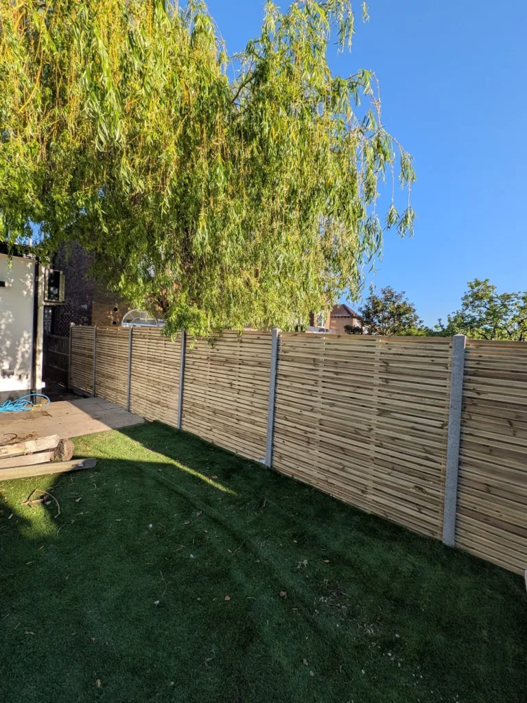The same Finchley N3 garden with new horizontal-slat fencing and a tidy lawn