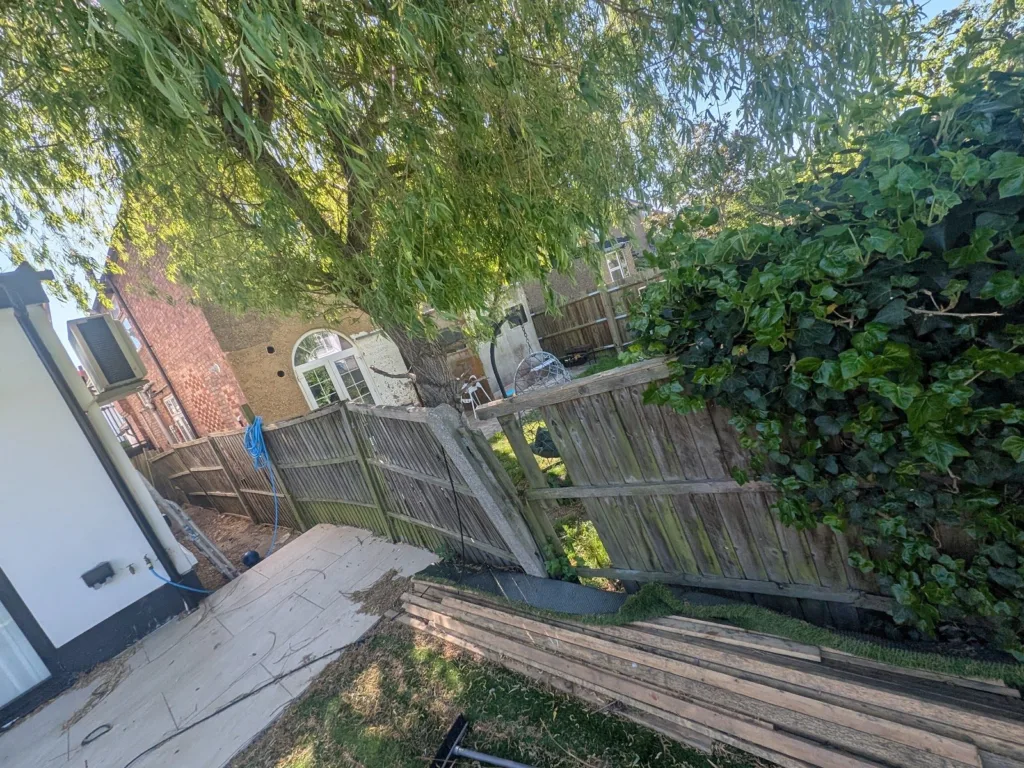 Rear garden in Finchley N3 with leaning, damaged fence panels before replacement