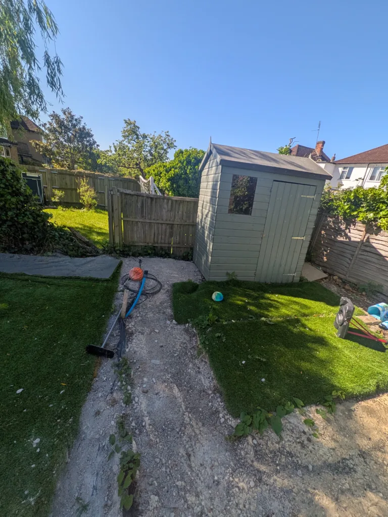 Garden shed corner with mud path and patchy grass before landscaping, Finchley N3
