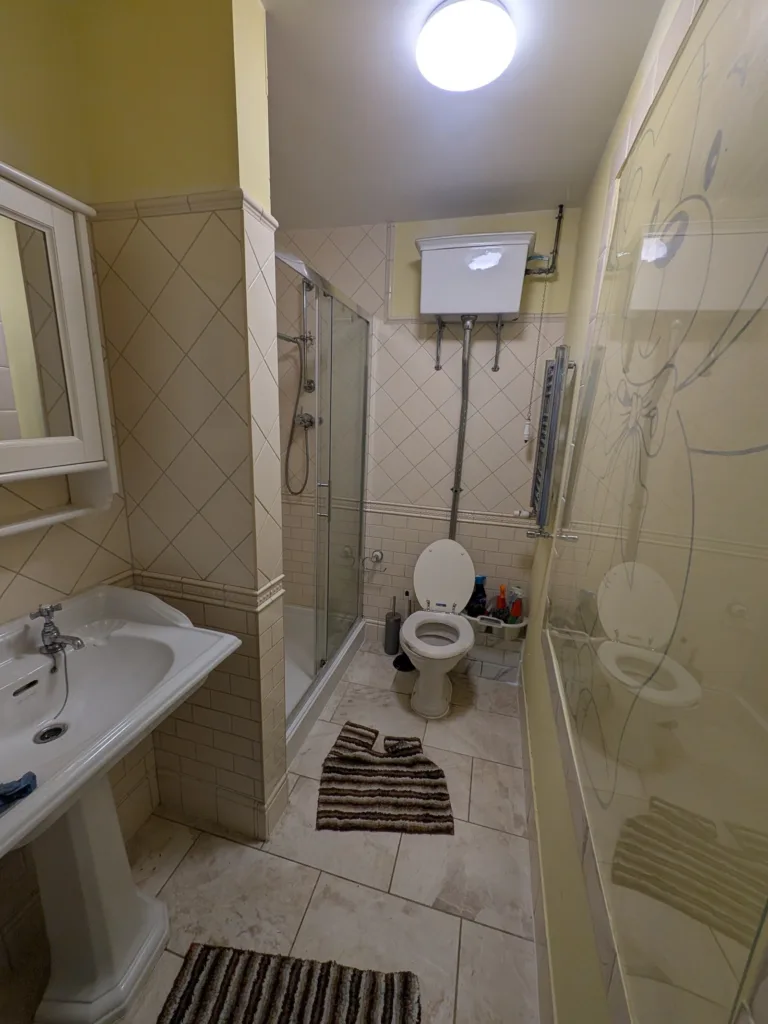 Dated bathroom in Pinner HA5 before refitting, with yellow walls and a high-cistern WC