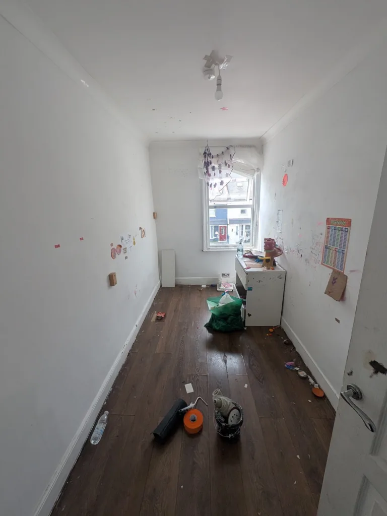 Small bedroom in Willesden NW10 before work, with marked walls and old dark flooring